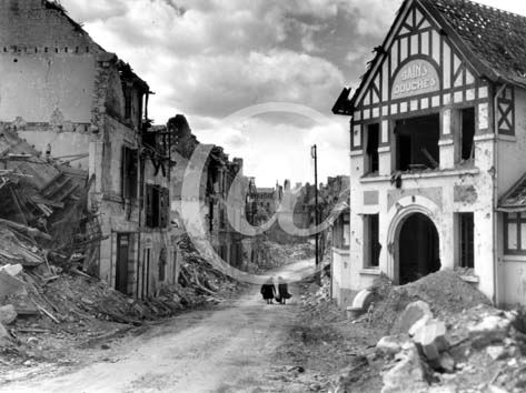 FALAISE(14700) 17 aot 1944 Deux femmes traversent la ville en ruines. Elles portent leurs maigres possessions. Au premier plan, les vestiges des Bains Douches.
